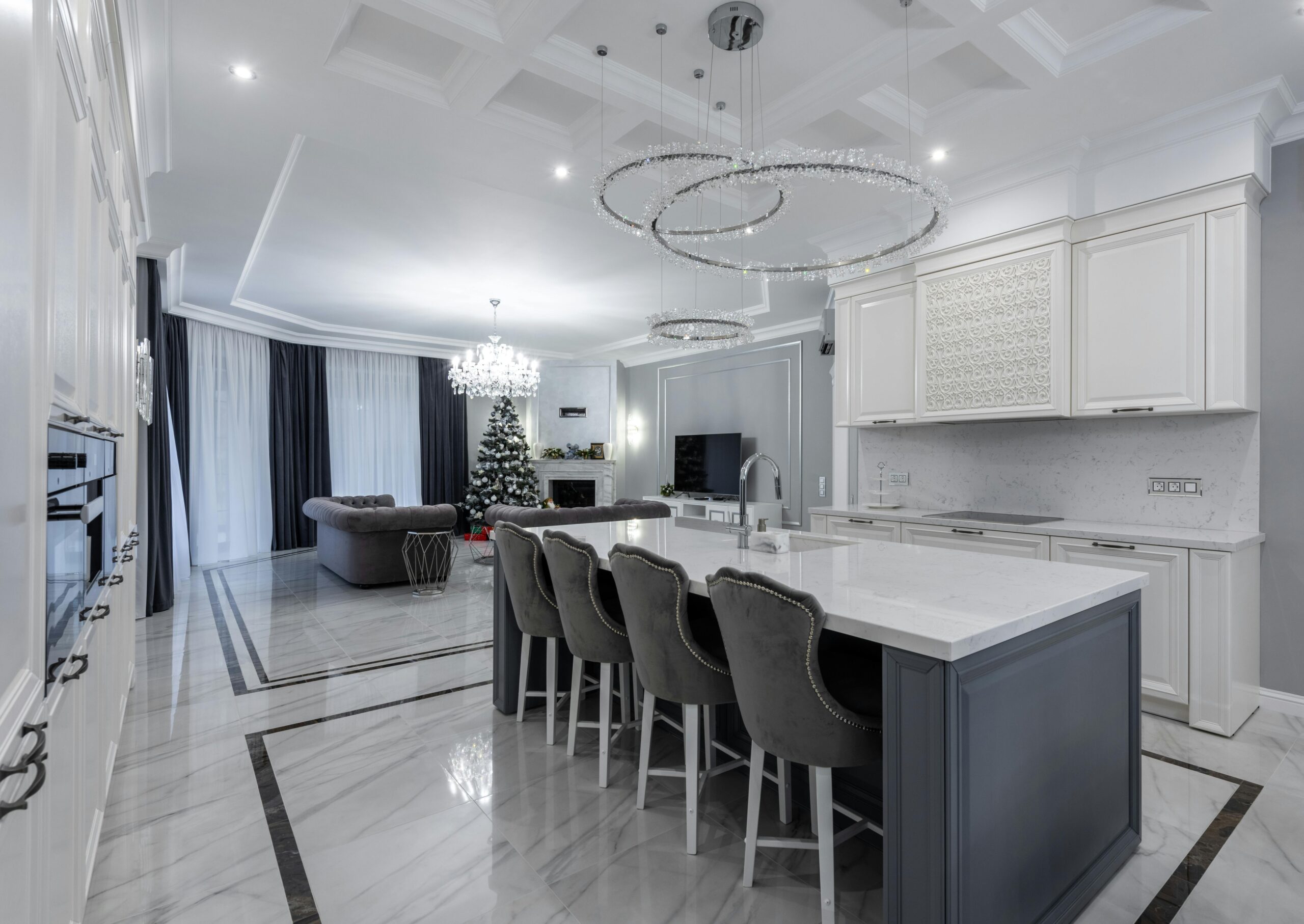 Interior of modern spacious kitchen with stylish furniture and living room with comfortable sofas and festive Christmas in daytime
